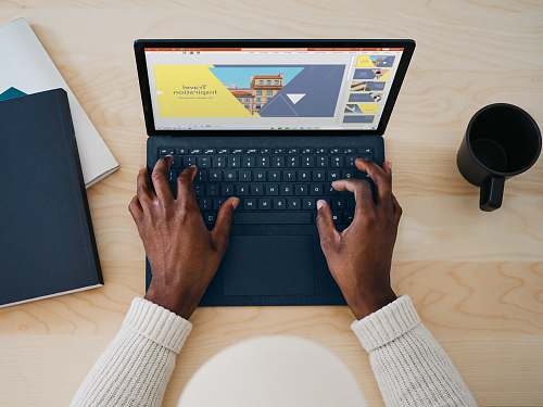 computer hardware person using cobalt blue microsoft surface laptop computer on a table  computer keyboard